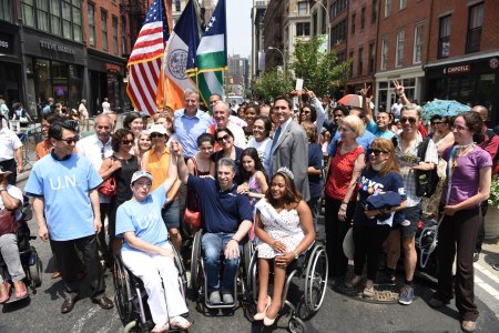 In 2015, New York Mayor Bill de Blasio declared July Disability Pride Month in celebration of the ADA’s 25th anniversary. Photo of the mayor and constituents celebrating. 