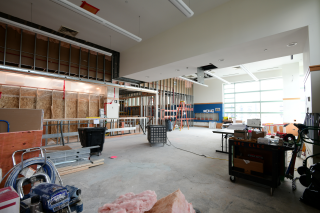View of The Canvas looking west, August 2024 with framed walls, construction materials and concrete floors. 
