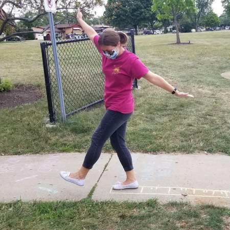 Ms. Steph balancing on one foot as she navigates an obstacle course. 