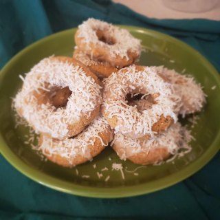 A green plate piled high with donuts. 