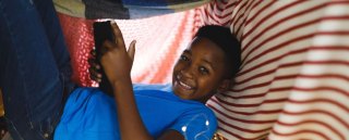 Man and child reading in a blanket fort