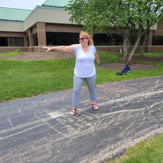 Woman with blond hair spinning on sidewalk