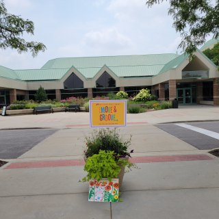 A yellow sign with the words move and groove in front of prairie lake park